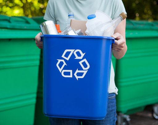 close up of woman carrying recycling bin